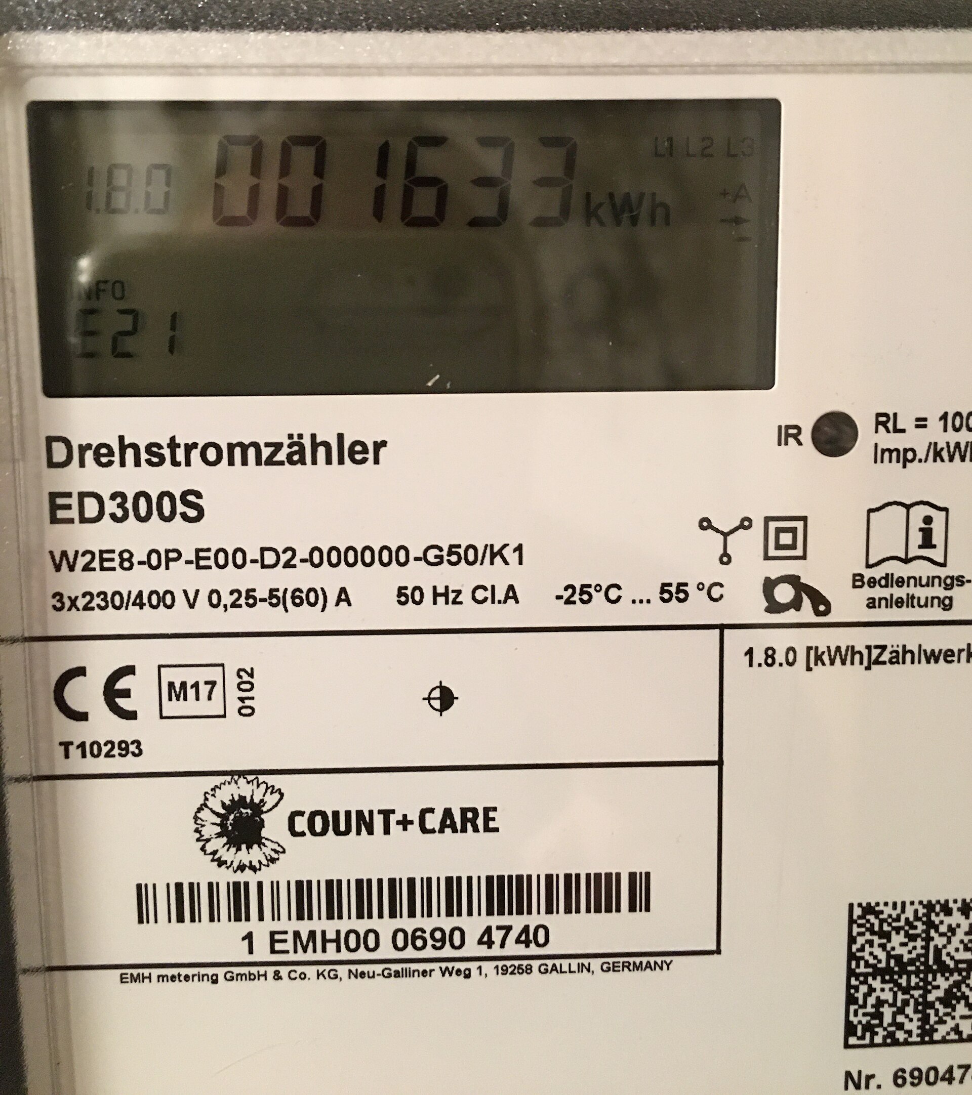 Nahaufnahme eines elektronischen Drehstromzählers EMH ED300S: Flüssigkristallanzeige mit 1.8.0 und Zählerstand, darunter Typenschild mit Nennwerten, Infrarotfenster rechts, CE- und M-Kennzeichnung und Zählernummer als Strichcode.